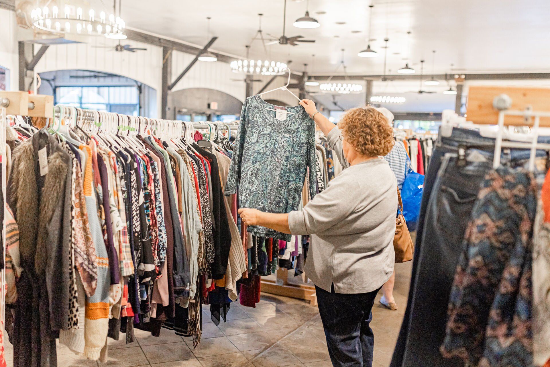 A woman is looking at clothes in a store.