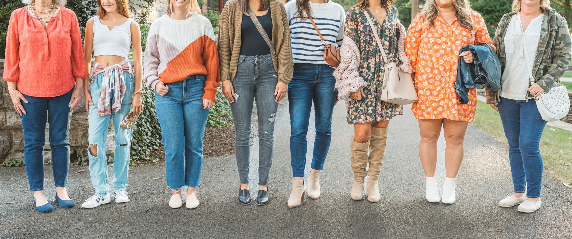 A group of women are standing next to each other on a sidewalk.