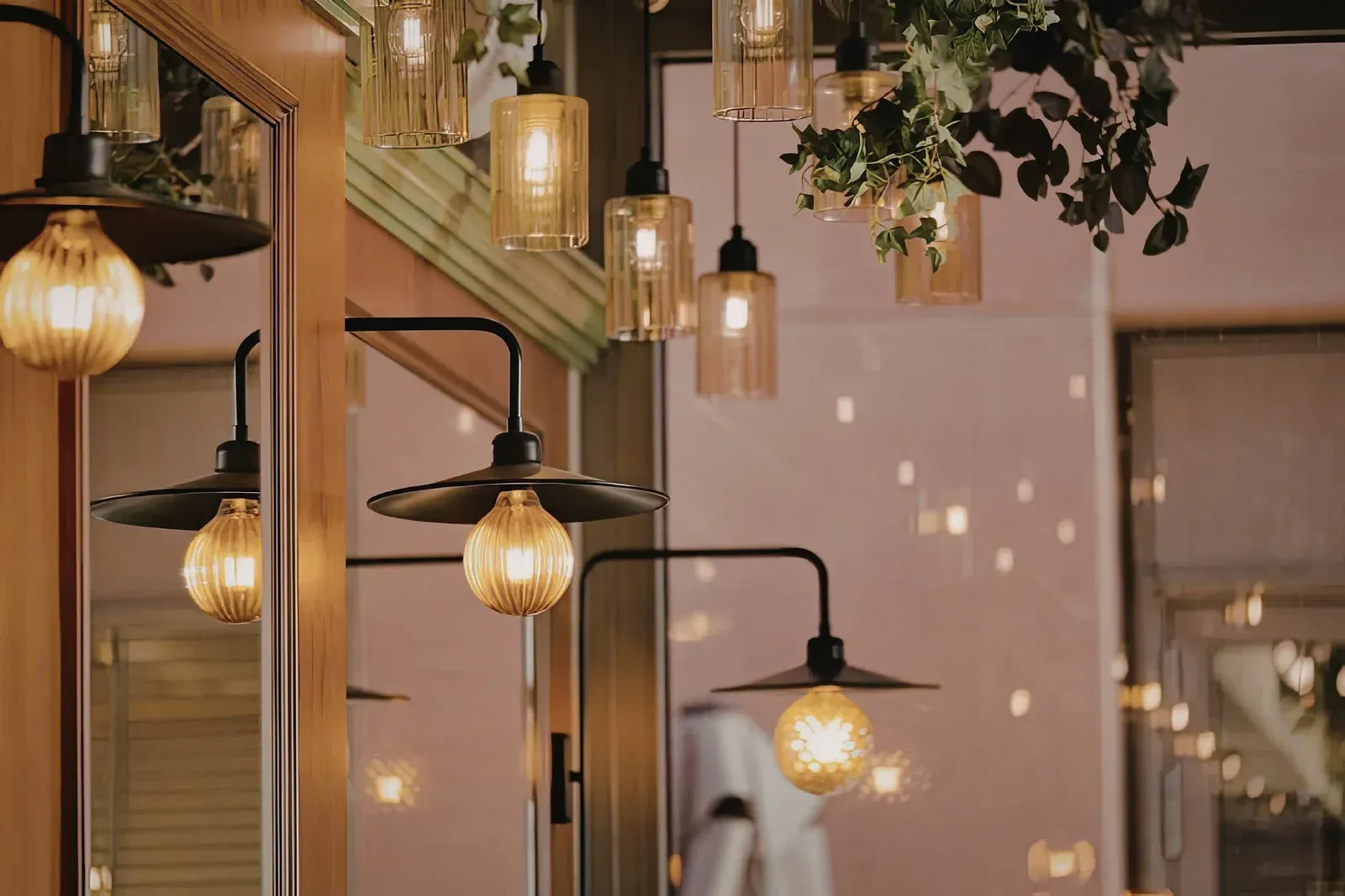 Multiple vintage-style pendant and wall-mounted lights with amber, glowing bulbs hanging in a warm, dimly lit room.