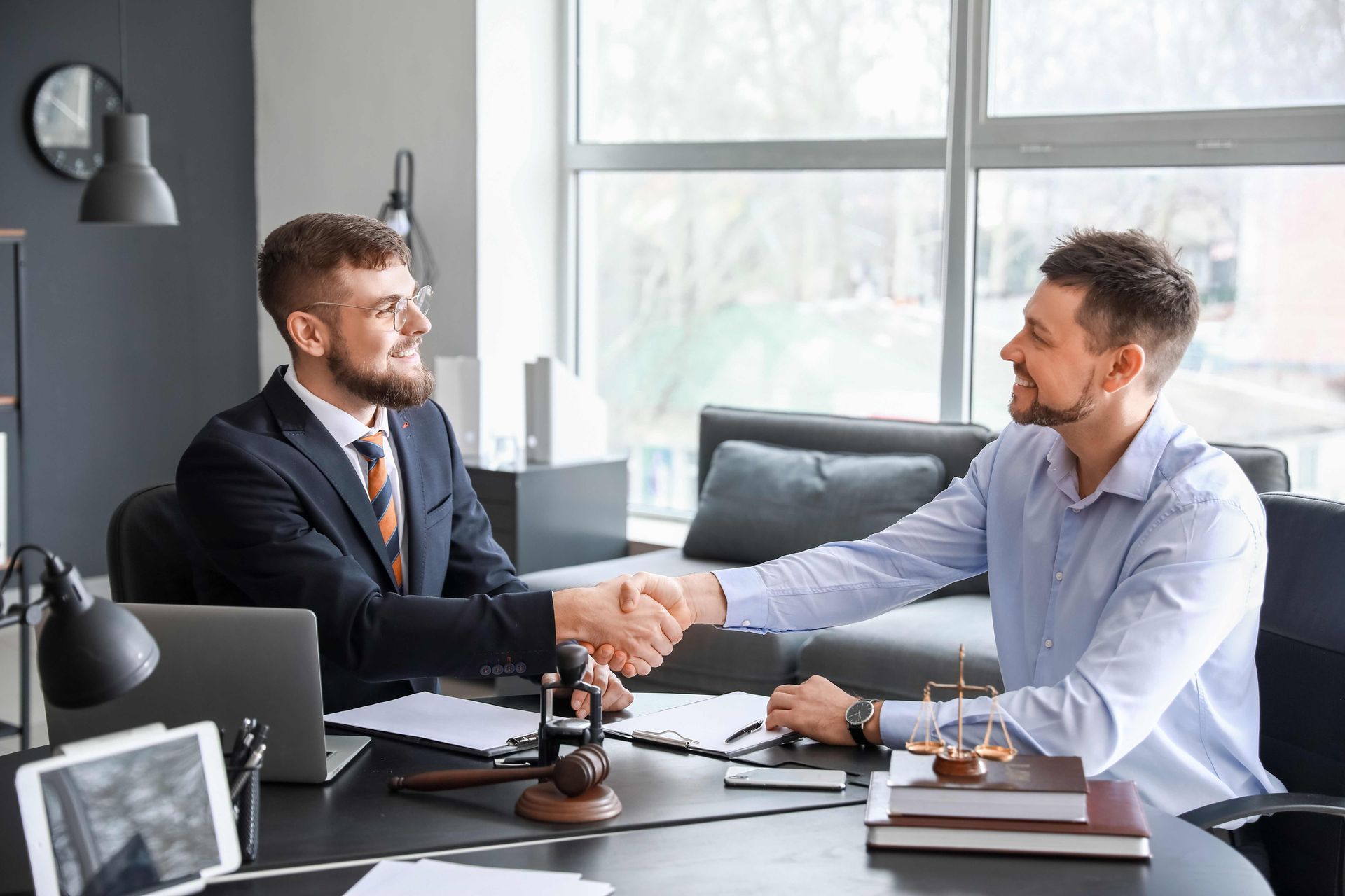 Male lawyer with client shaking hands in office Male lawyer with client shaking hands in office