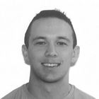 A man is smiling in a black and white photo.