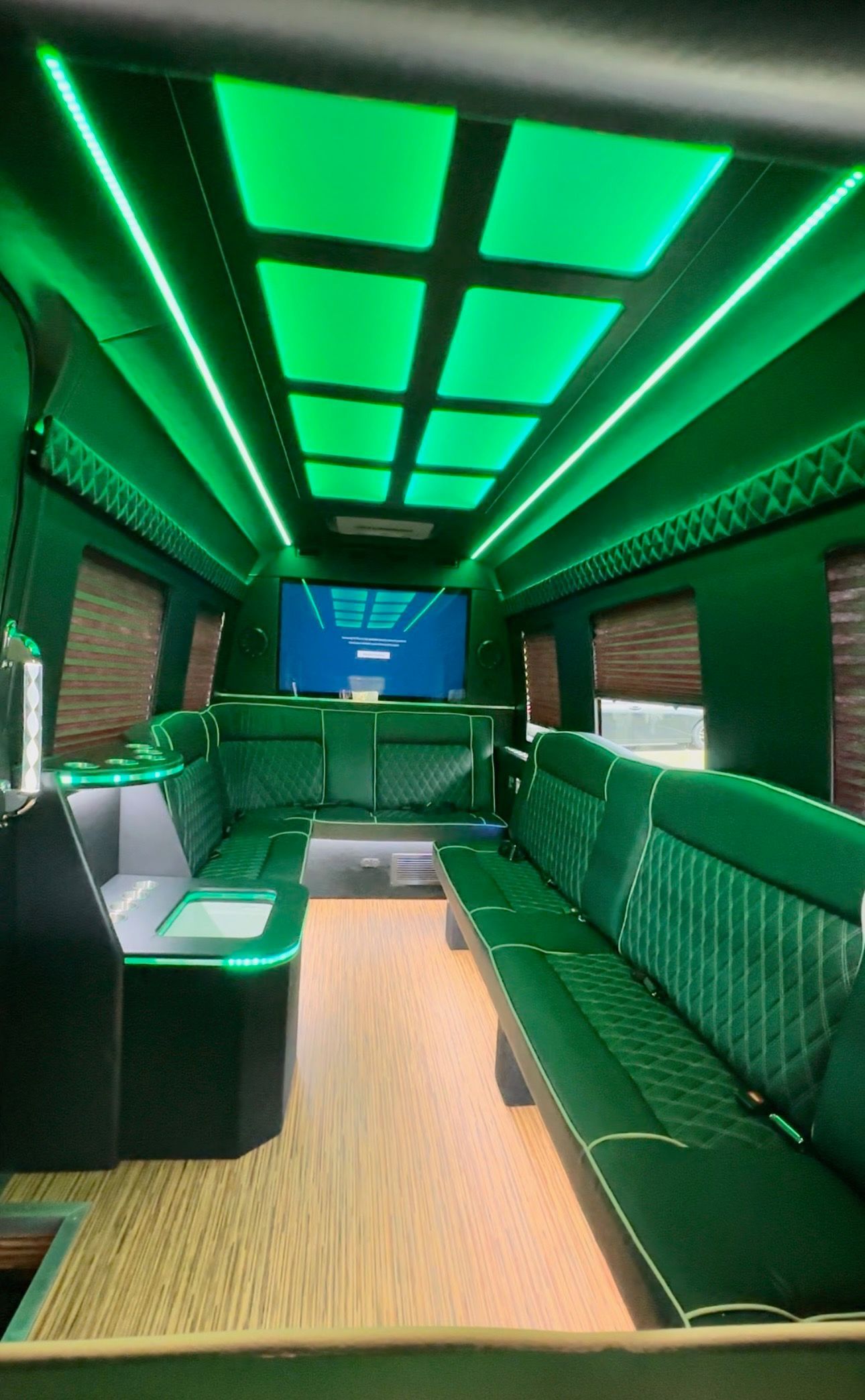 The inside of a limousine with green lights on the ceiling
