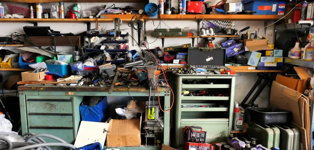A messy garage filled with lots of tools and boxes.