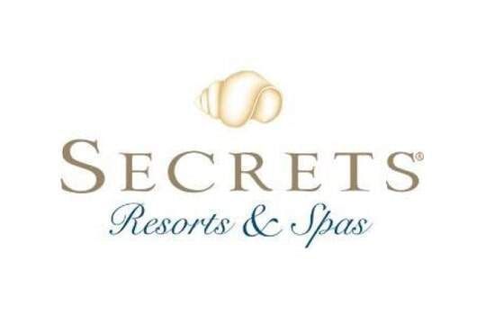 Logotipo de Secrets Resorts & Spas con forma estilizada de color crema sobre las palabras 
