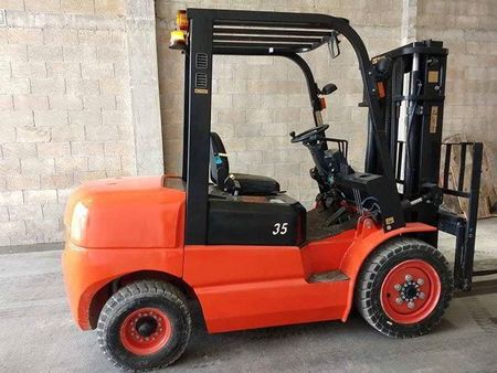 Carretilla elevadora naranja con detalles en negro en un entorno de almacén.