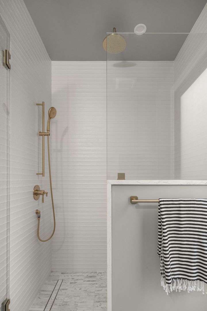 A bathroom with a walk in shower and a towel rack.