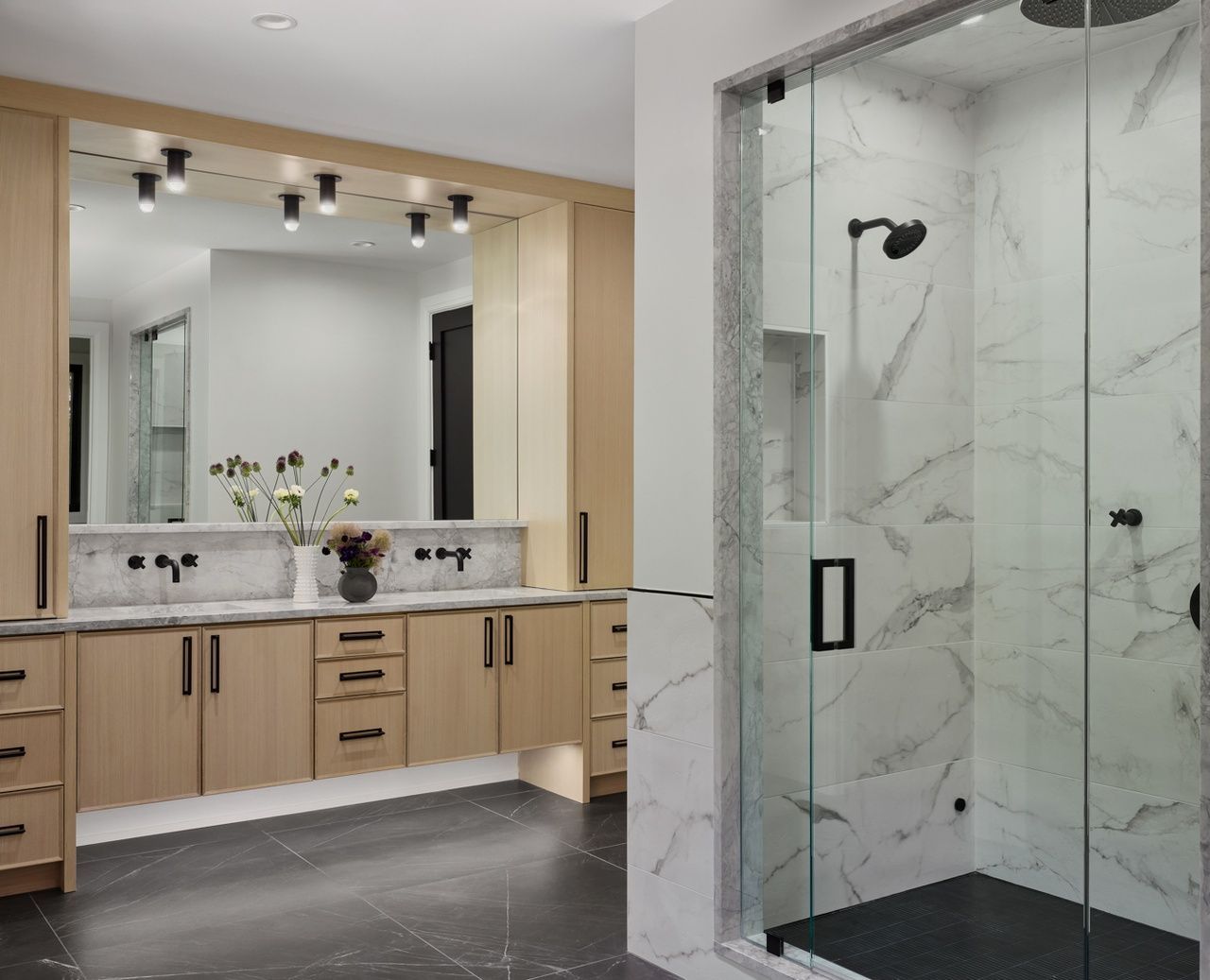 A bathroom with two sinks and a walk in shower.