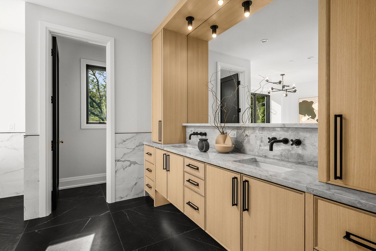 A bathroom with two sinks and a large mirror.