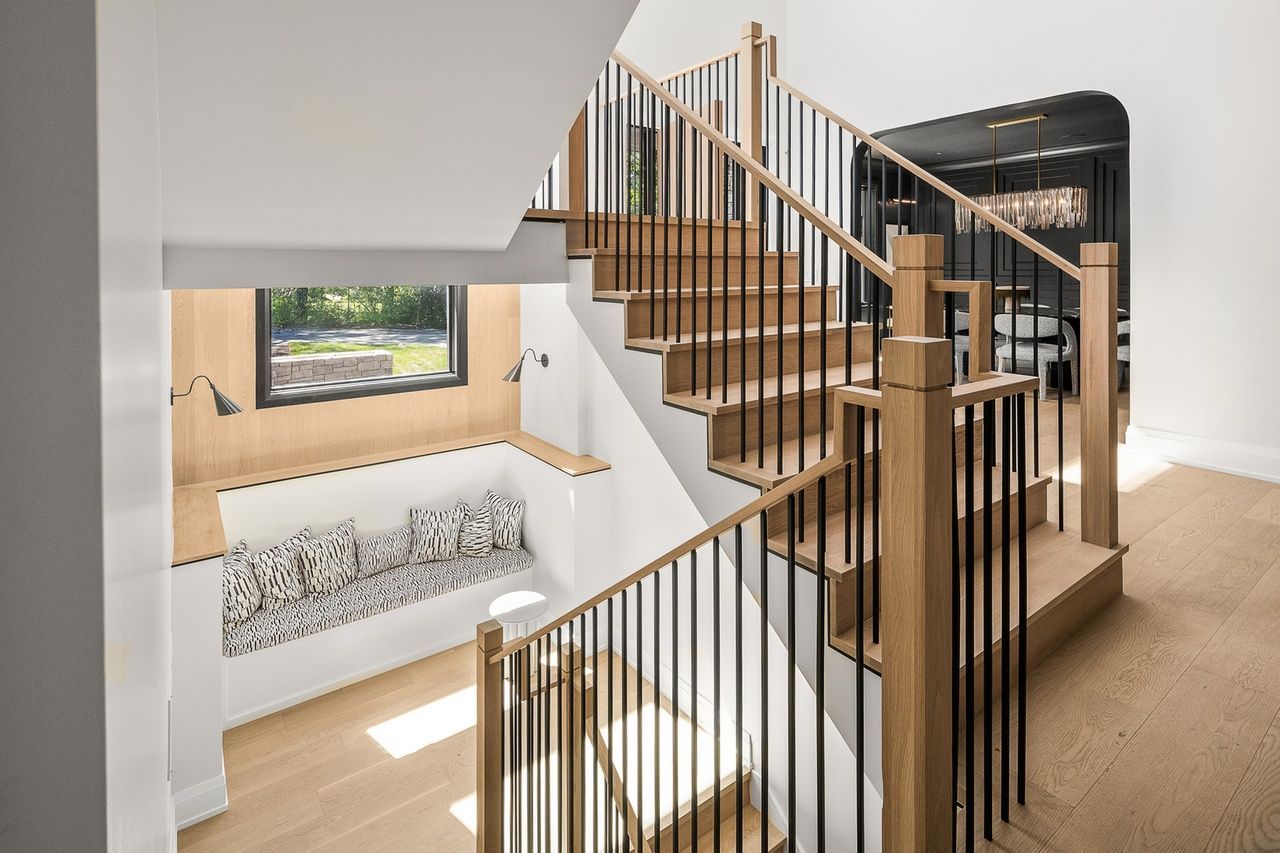 A wooden staircase with a metal railing in a house.