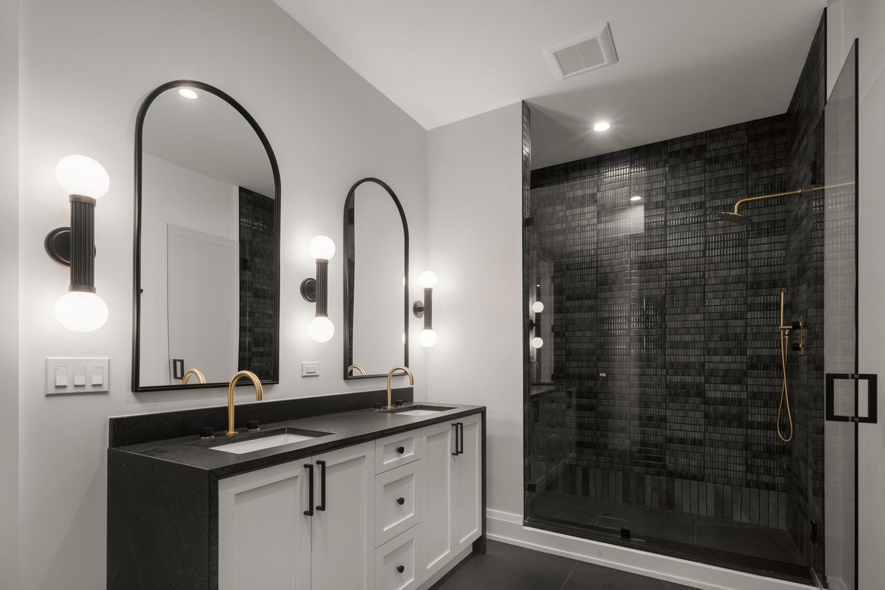 A bathroom with two sinks and a walk in shower.