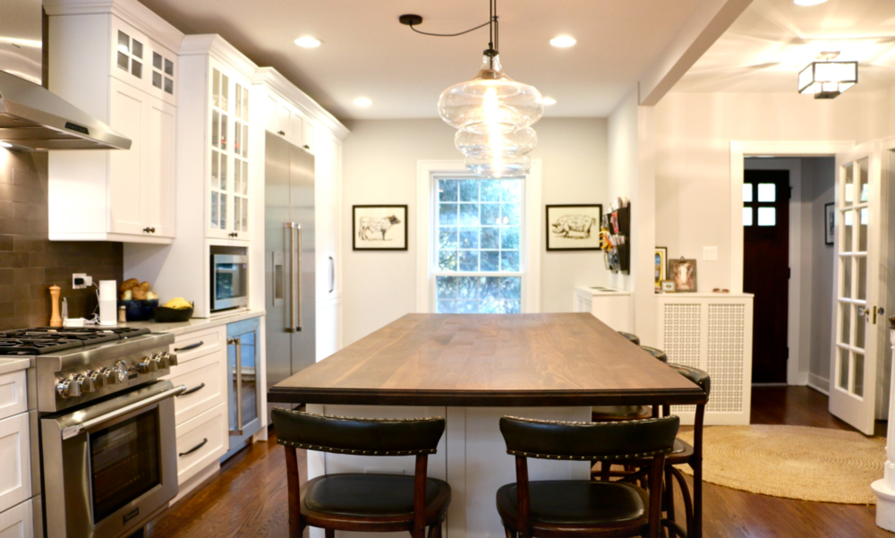 A kitchen with a large wooden table and chairs