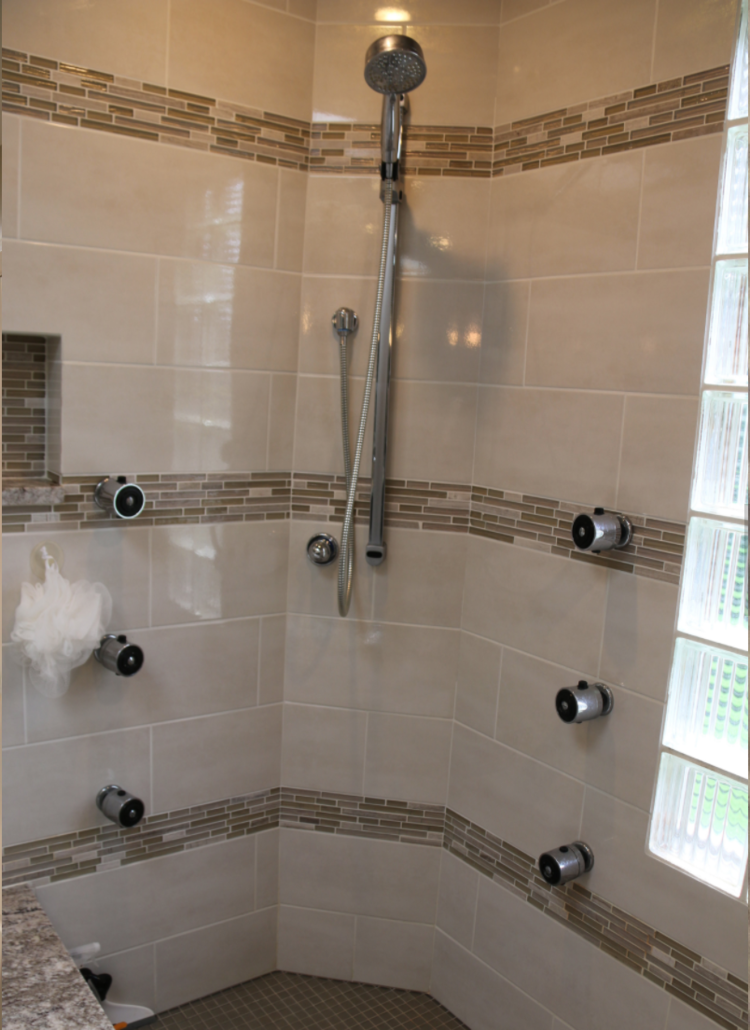 A shower with a glass door and a shower head