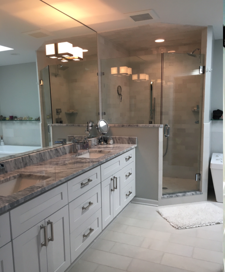 A bathroom with two sinks and a walk in shower
