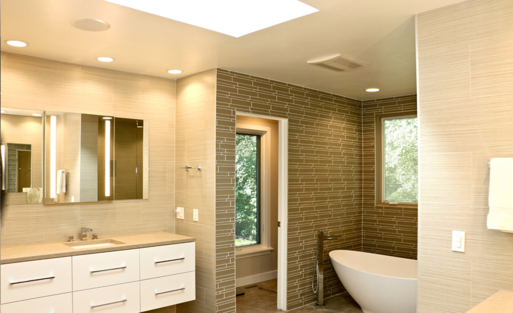 A bathroom with a tub , sink and mirror