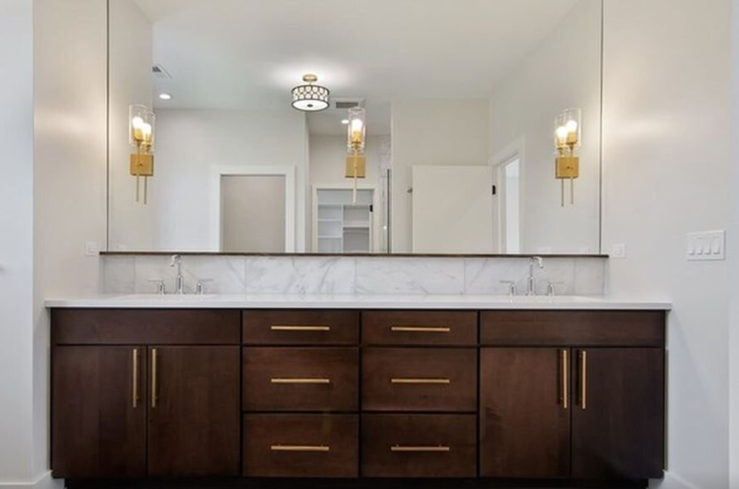 A bathroom with two sinks and a large mirror.
