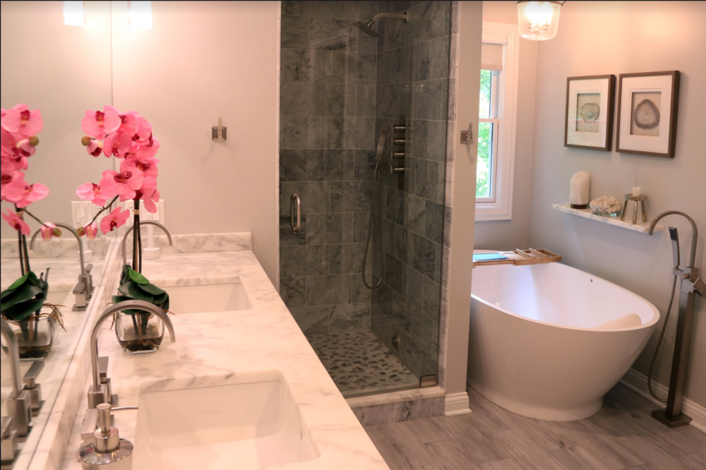 A bathroom with two sinks , a tub , a shower and a mirror.