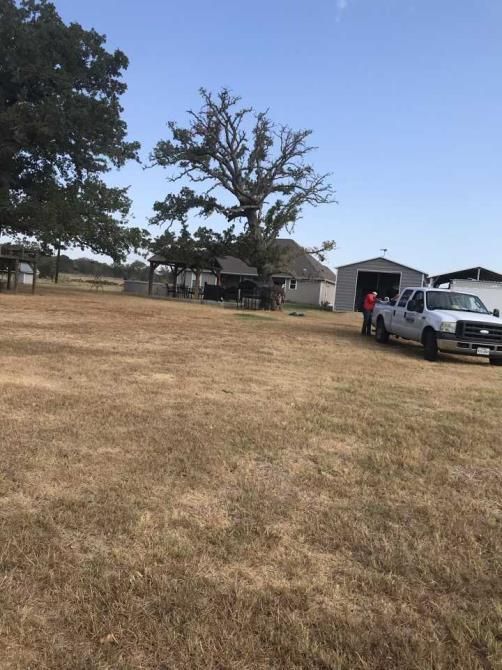 A white truck is parked in a dry grass field