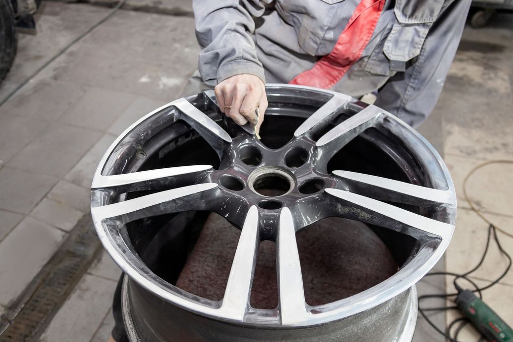 Un uomo sta lavorando sulla ruota di un'auto in un garage.