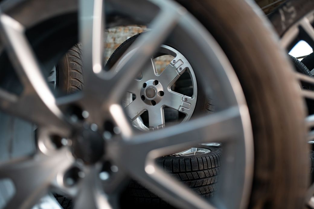 Un primo piano della ruota di un'auto con uno pneumatico sullo sfondo.