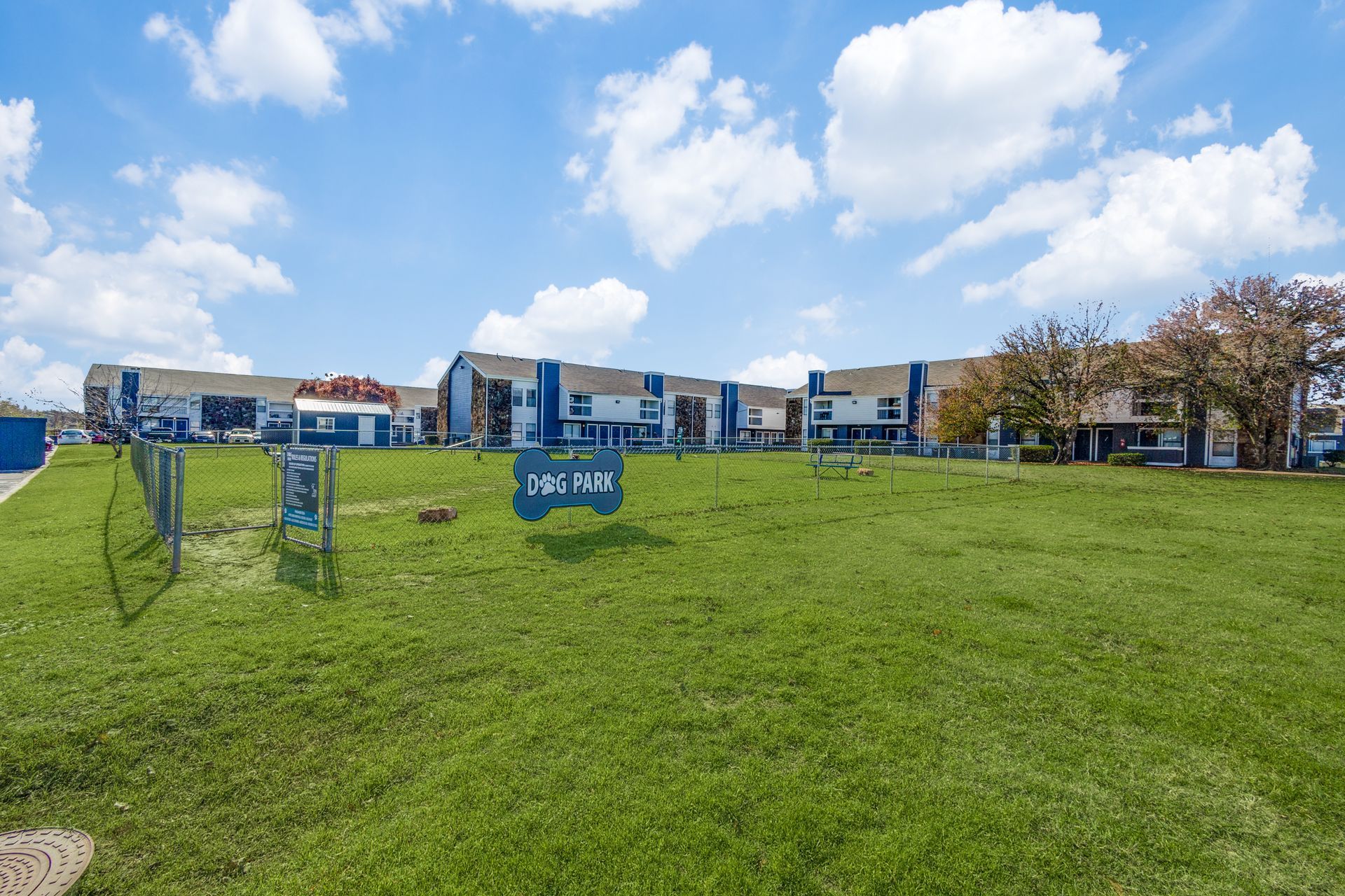 Exterior view of blue and white apartment buildings on a green lawn with a 