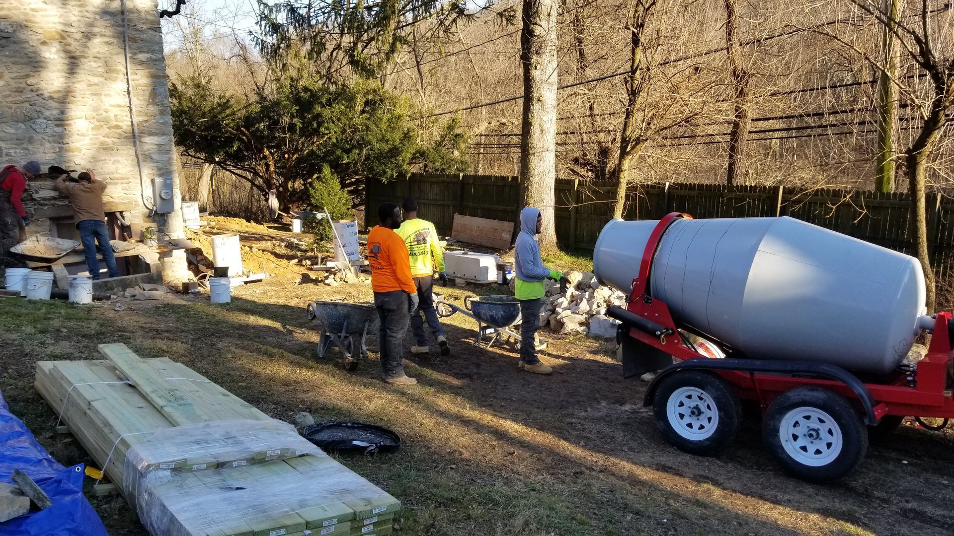a concrete mixer is being used to mix concrete in a yard .