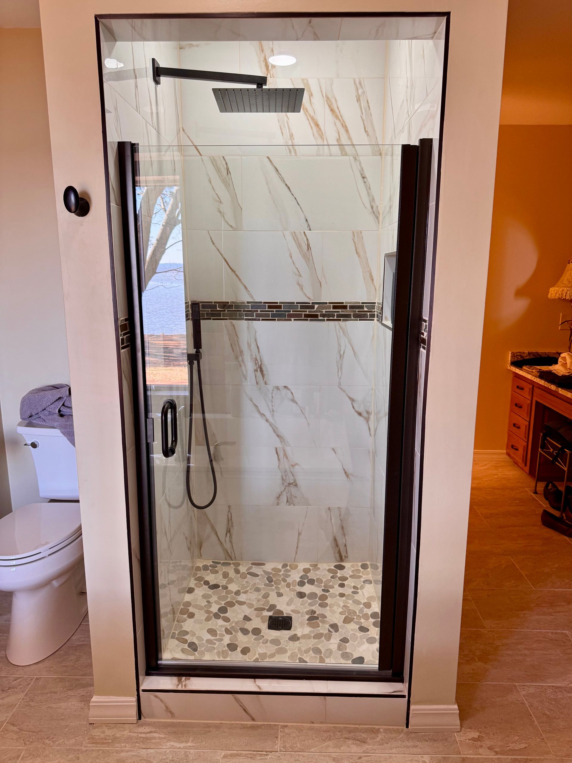 A bathroom with a walk in shower and a toilet