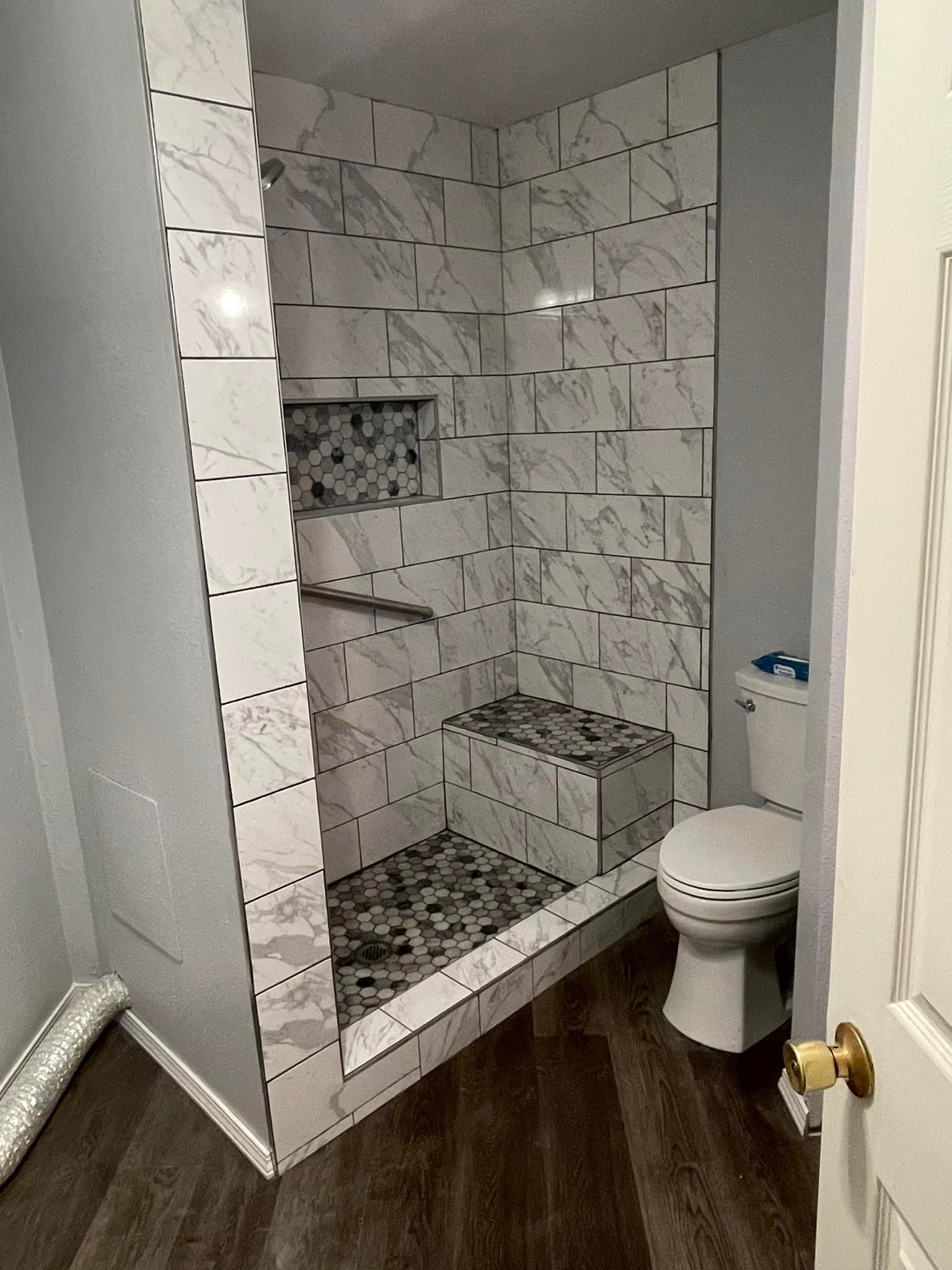 A bathroom with a toilet and a walk in shower.