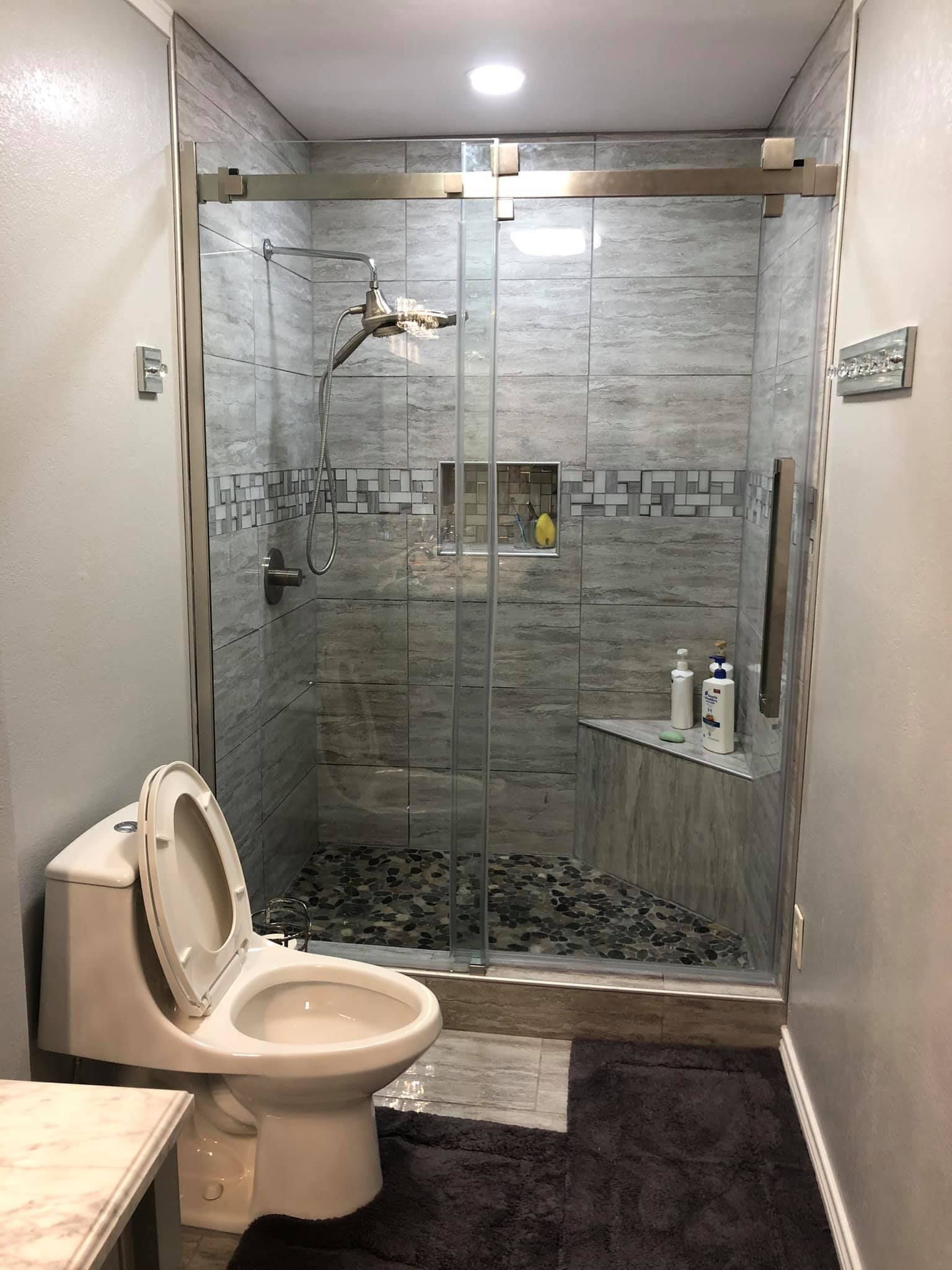 A bathroom with a toilet and a walk in shower.