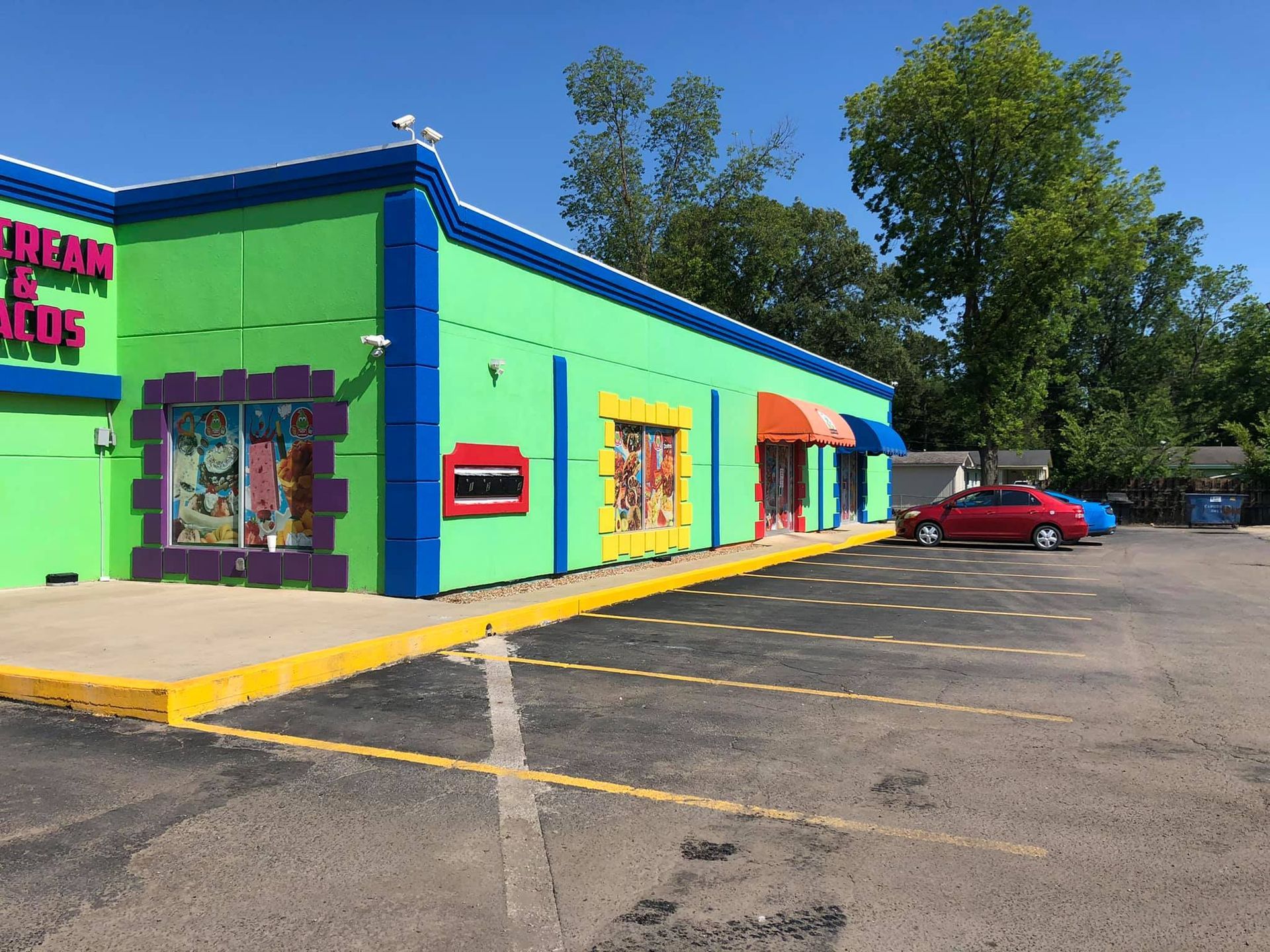 A colorful building with a red car parked in front of it