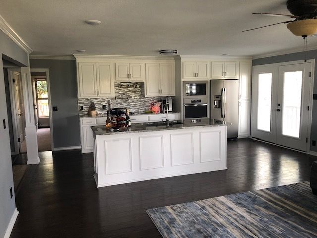 A kitchen with white cabinets and stainless steel appliances