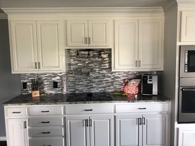 A kitchen with white cabinets and granite counter tops