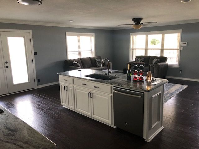 A kitchen with a large island and a stainless steel dishwasher