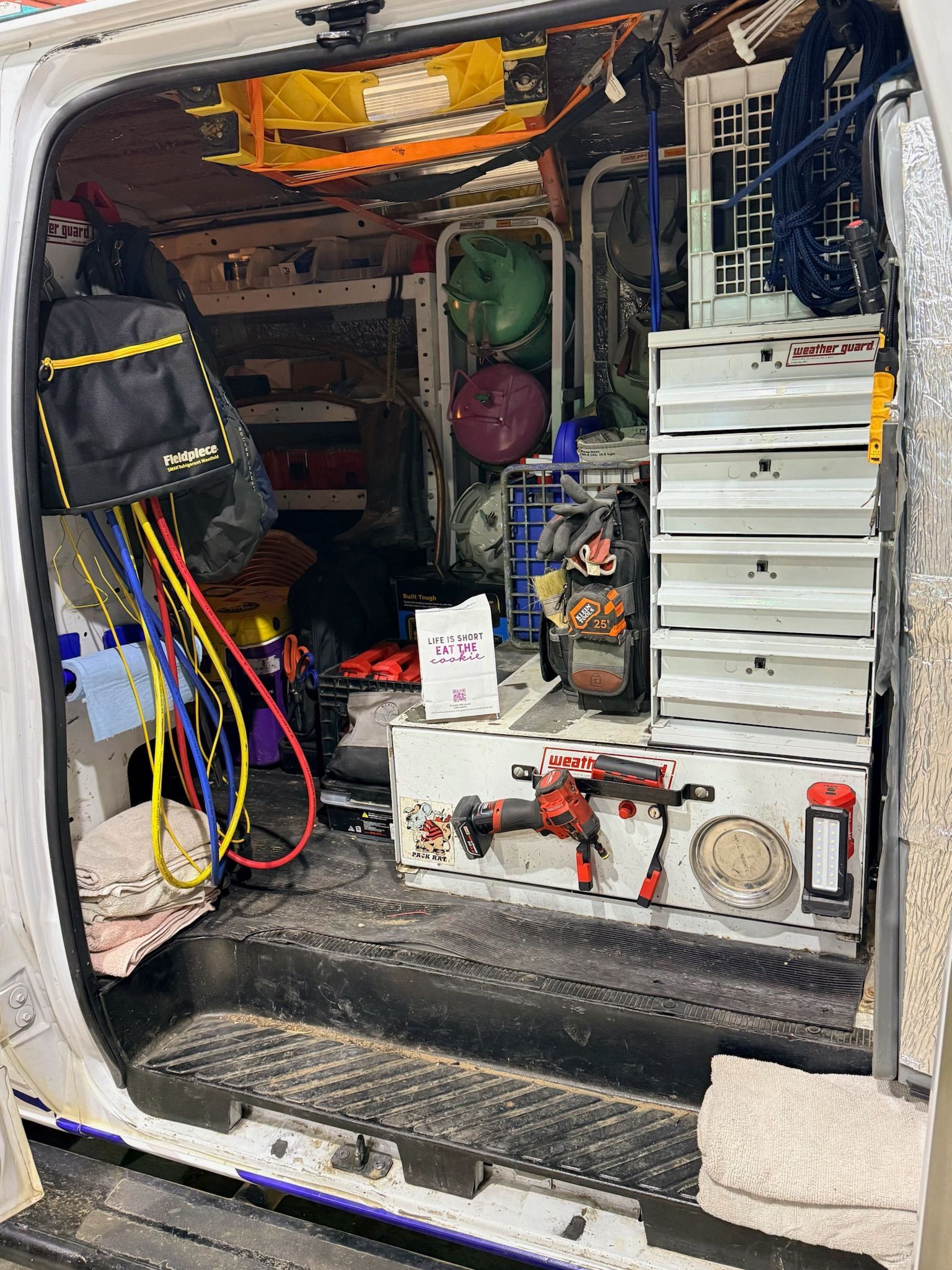 Inside of a utility van packed with tools, storage drawers, and equipment.