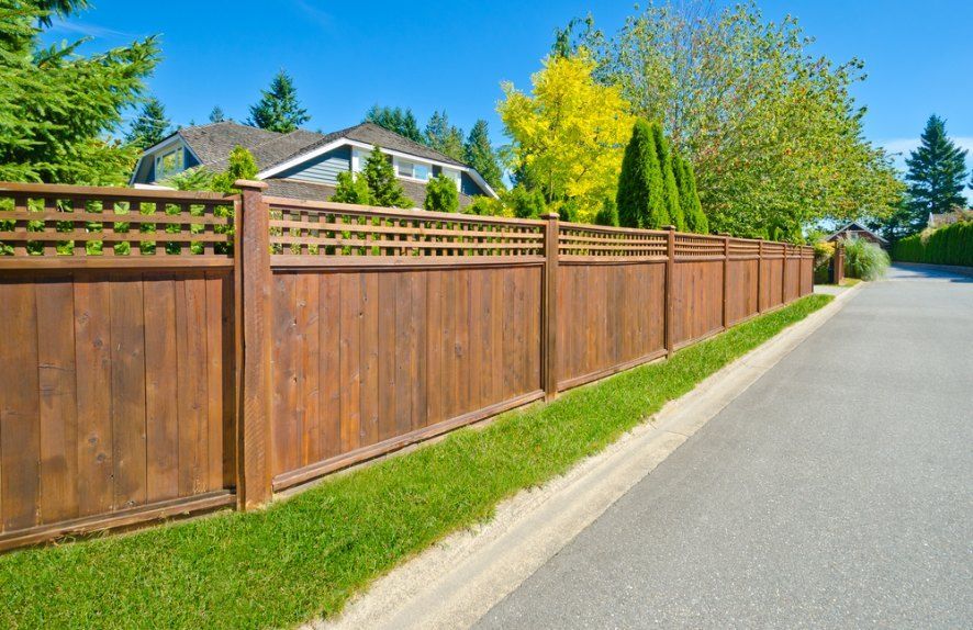 Brown Wooden Fence Along a Road With a House — Capital Fencing in Charnwood, ACT
