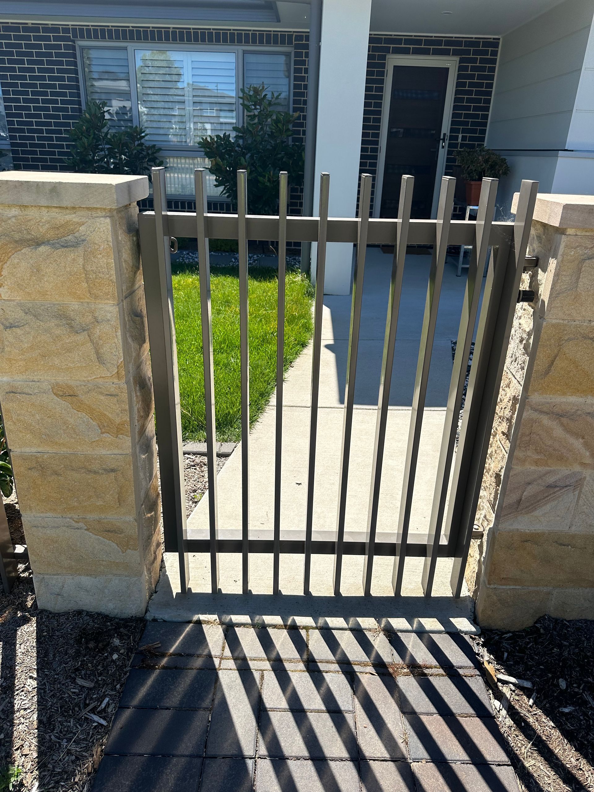 Modern Slat Fencing Gate Between Stone Pillars — Capital Fencing in Charnwood, ACT