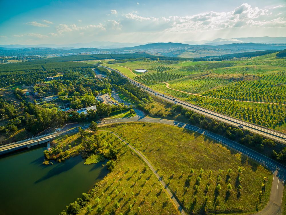 Aerial View of a Green Landscape With a Highway, Trees, a Lake — Capital Fencing in Tuggeranong, ACT
