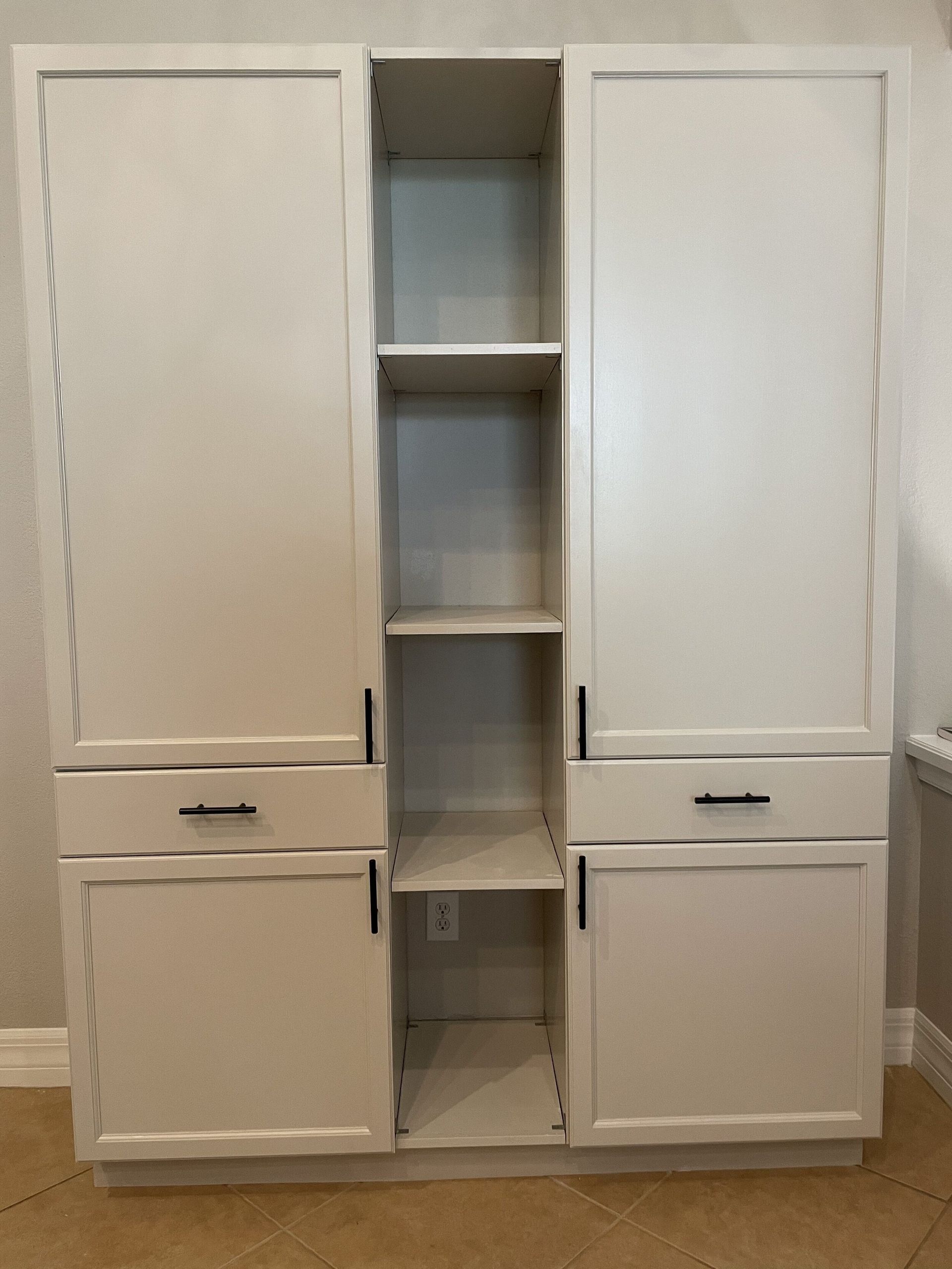 Tall, off-white kitchen cabinet with center shelves and two doors, two drawers. Black handles.