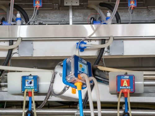 Industrial equipment with blue sensor boxes and cables mounted on a metal panel
