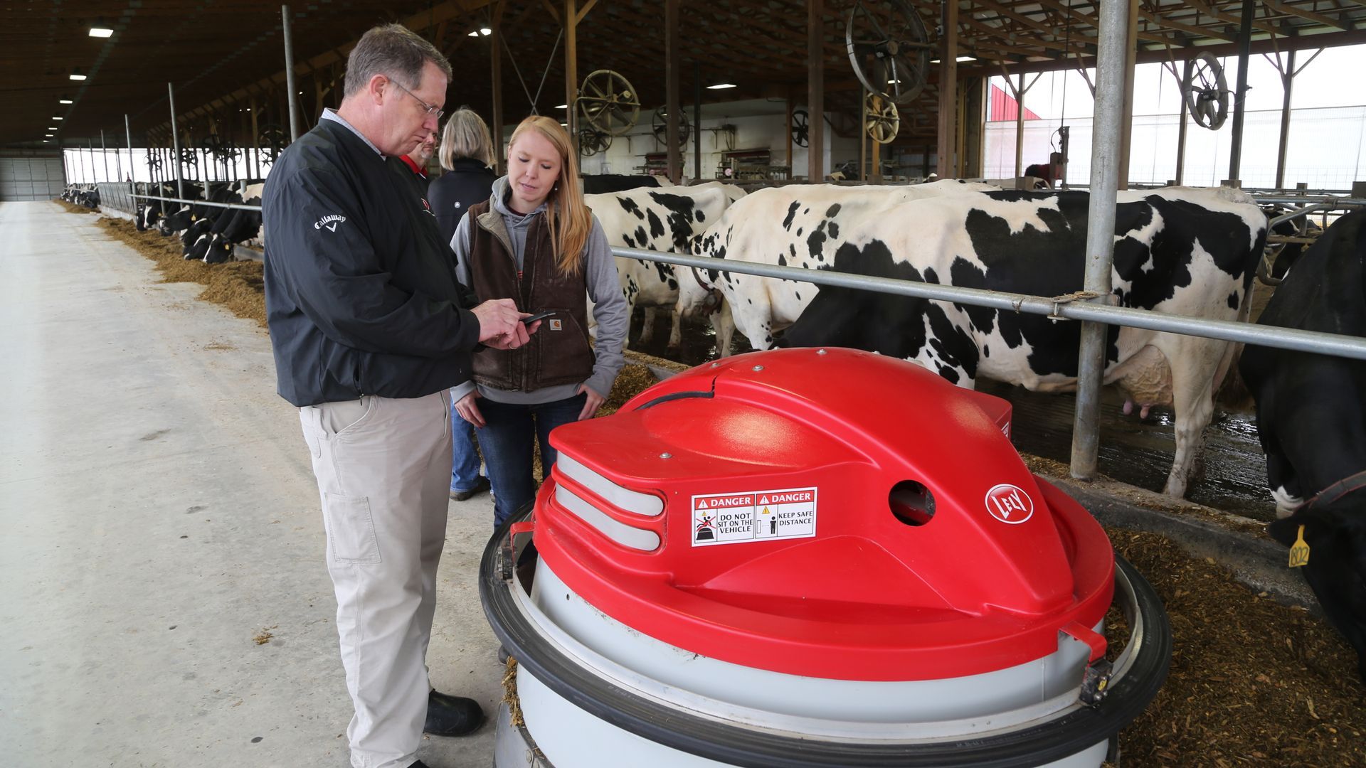 Everstead Farm Supply staff demonstrating Lely robotic milking equipment in dairy barn