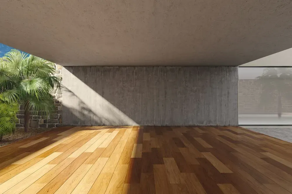 An Empty Room With a Wooden Floor and a Concrete Wall — Shane Callinan Floor Sanding In Bonny Hills, NSW