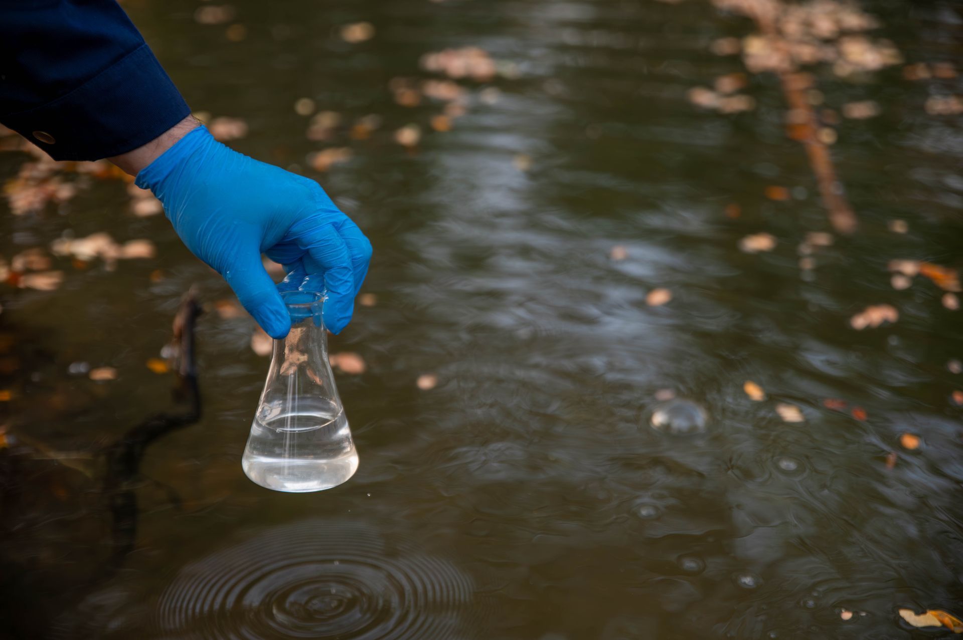 Technician collecting a water sample for well testing