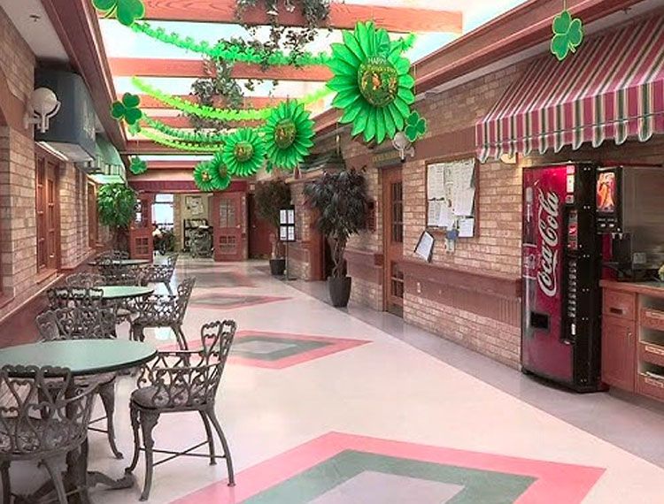 Interior hallway with tables, Coca-Cola machine, and St. Patrick's Day decorations.