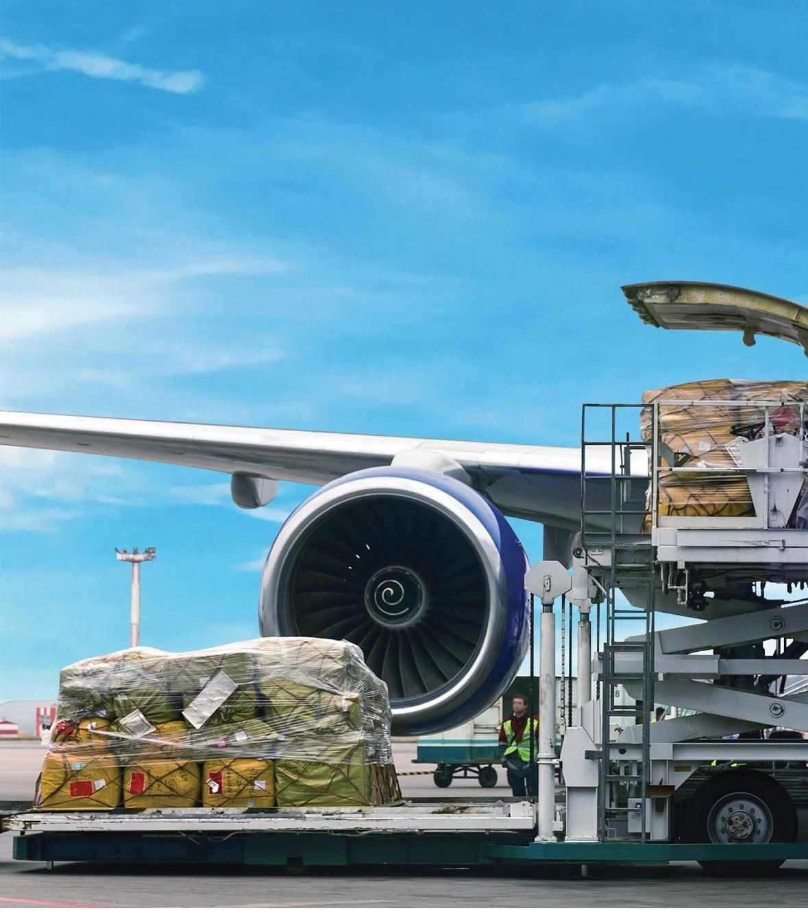 cargo legacy - Cargo plane being loaded with freight on the tarmac; blue sky background.