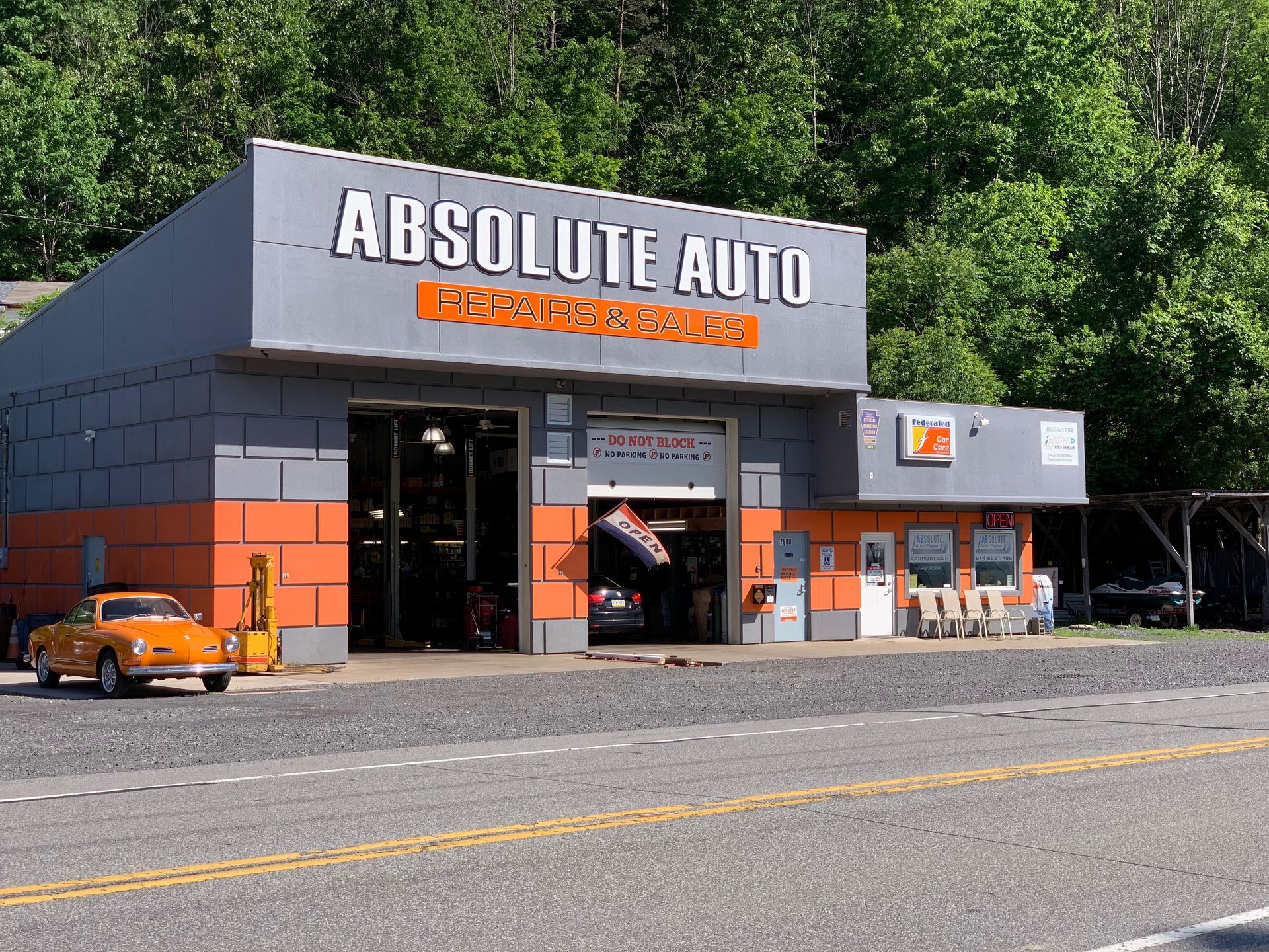 Absolute Auto repair shop exterior with orange and grey facade, orange car parked out front. | Absolute Auto Repairs & Sales