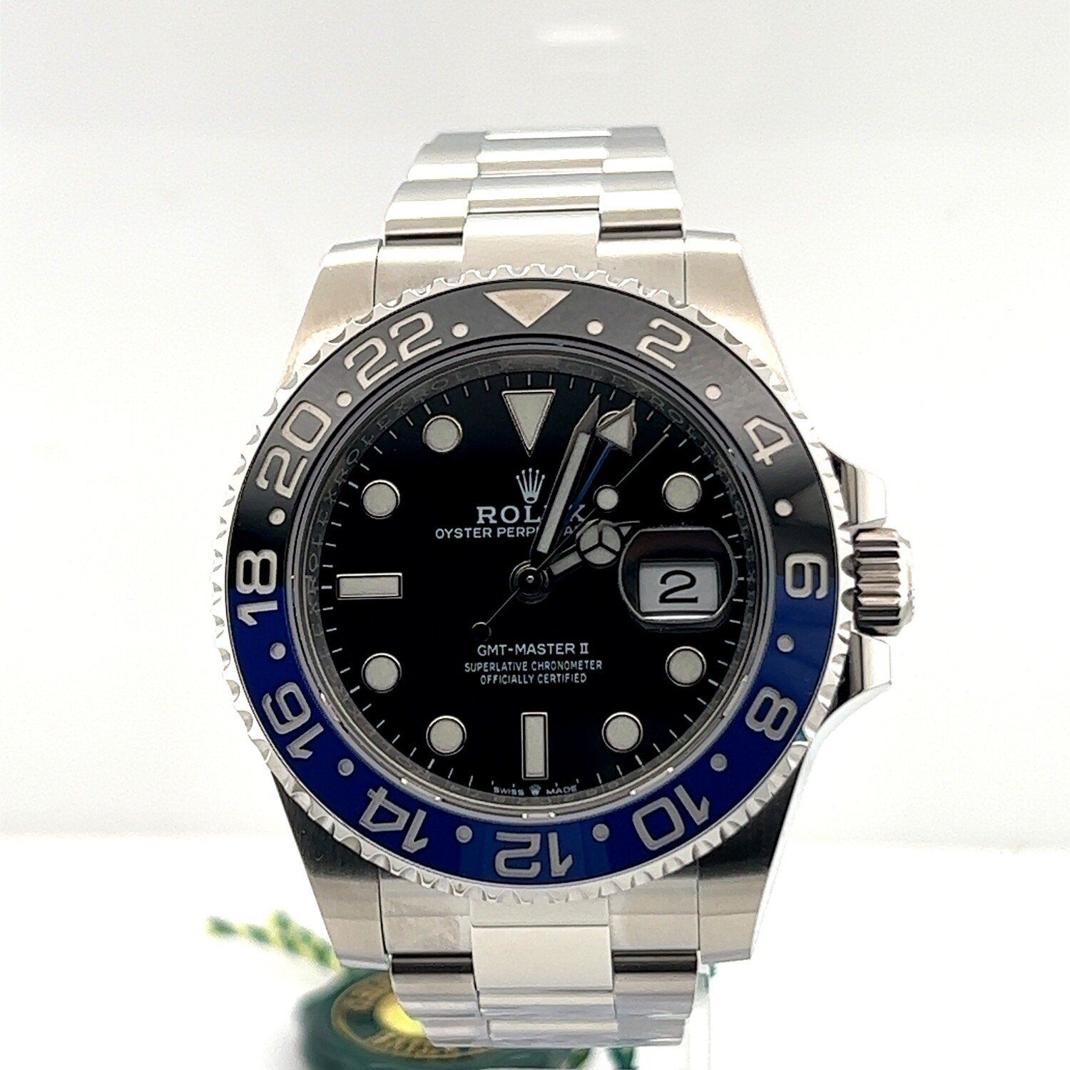 A silver and blue rolex watch is sitting on a table.