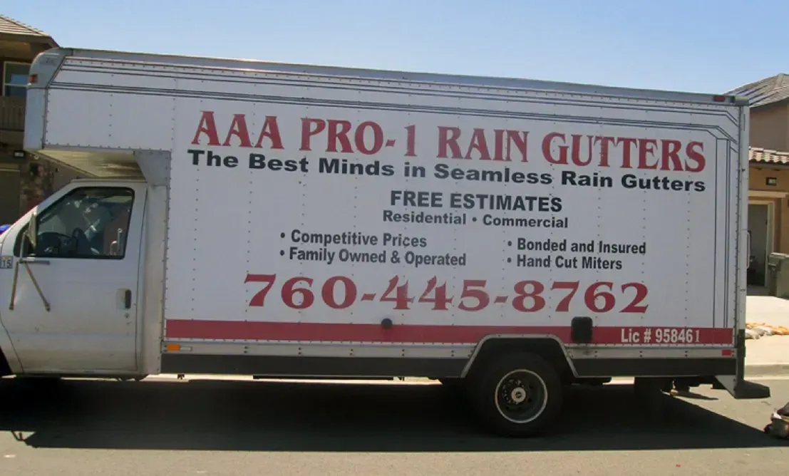 White truck with AAA Pro-1 Rain Gutters business advertisement and phone number 760-444-8762
