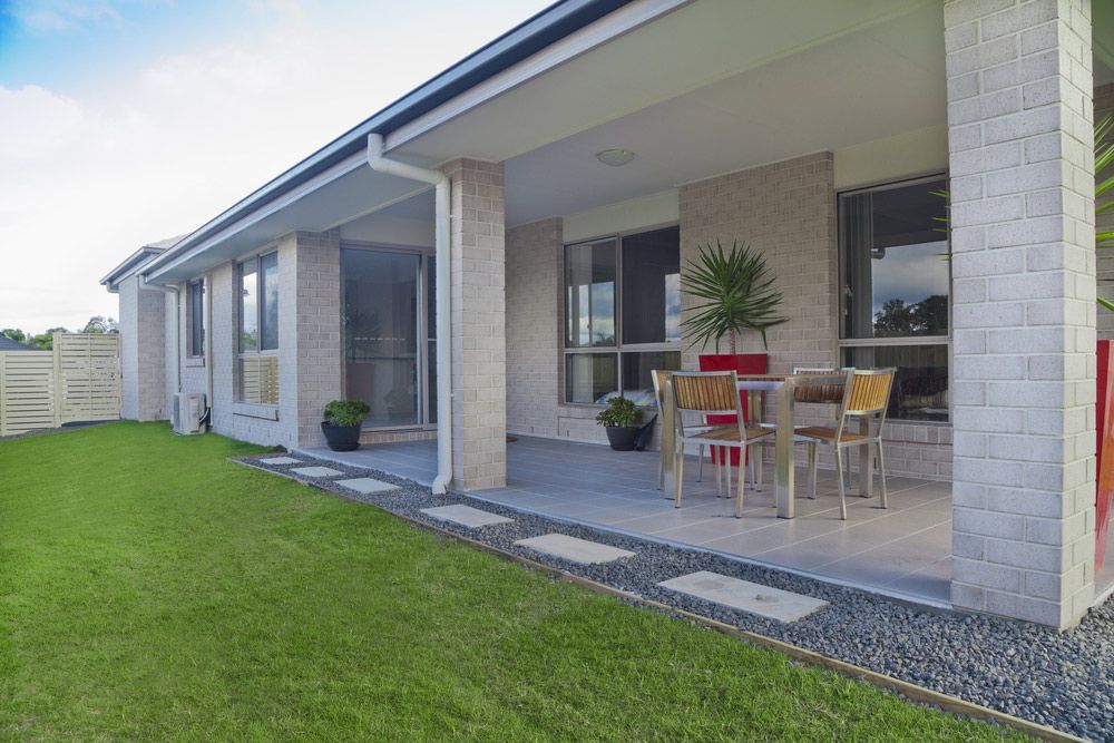There Is a Patio with A Table and Chairs in Front of A House — Iconic Construction Industries in Garbutt, QLD
