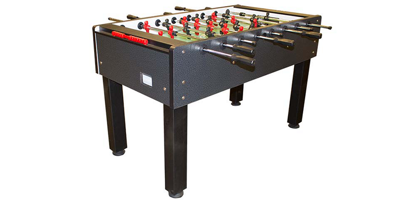 A black foosball table with red and green balls on it on a white background.