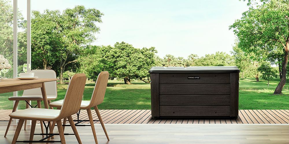 A patio with a table and chairs and a hot tub.