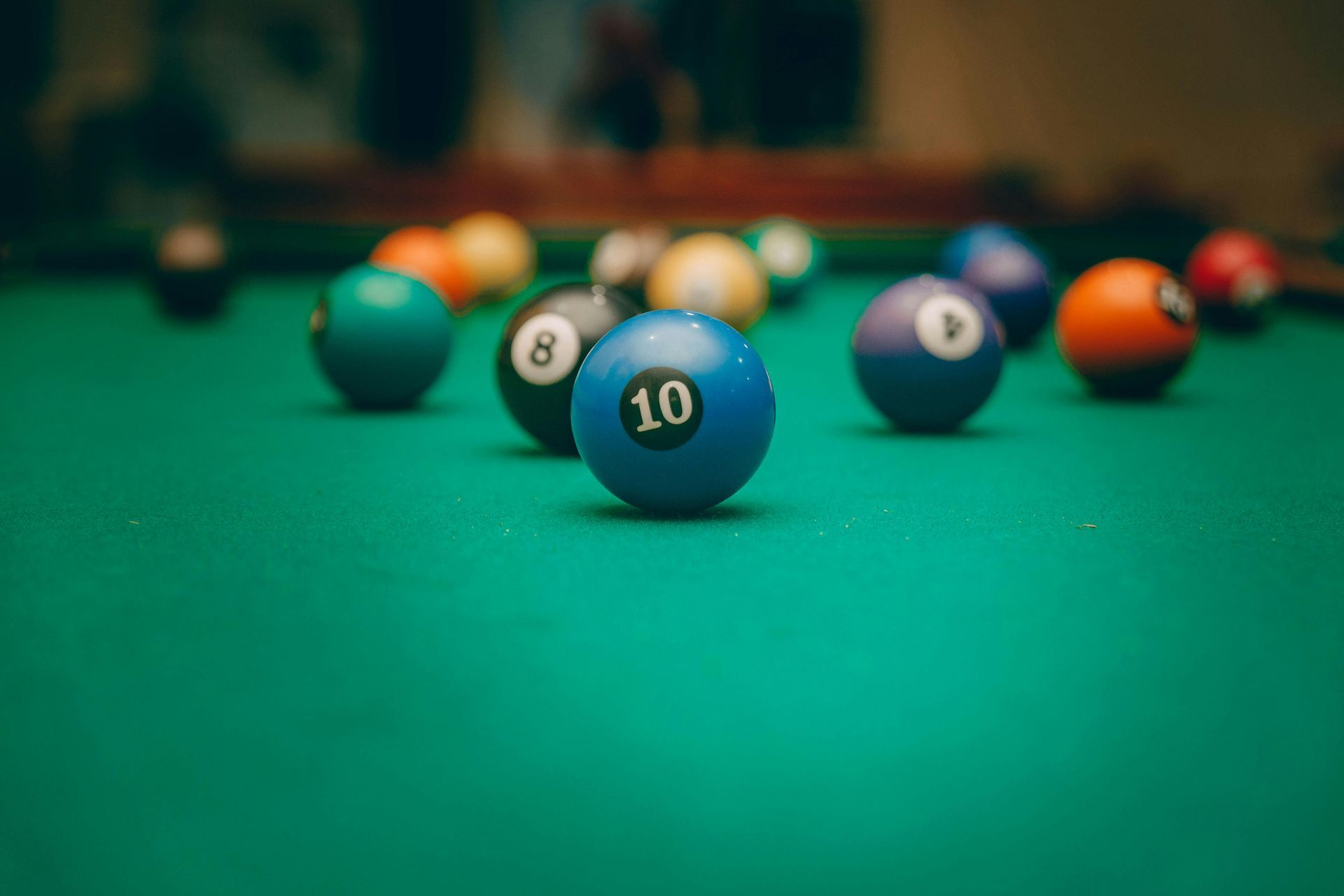 A pool table filled with pool balls of different colors.